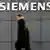 A man passes a Siemens sign