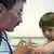 Ein Arzt gibt einem Kind eine Spritze in den Oberarm, aufgenommen am 04.03.2006 in Stuttgart. Foto: Jürgen Effner +++(c) dpa - Report+++