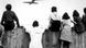 Black and white 1948 photo of children on rooftop of West Berlin watching airplane flying above Black and white 1948 photo of children on rooftop of West Berlin watching airplane flying above