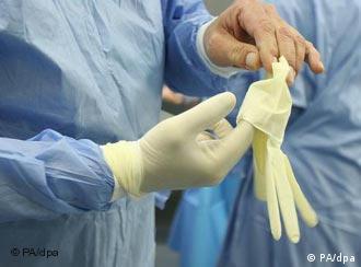 A doctor pulls on his surgical gloves