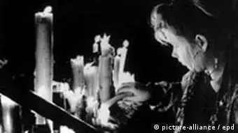 Frau zündet Kerze an