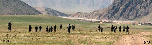 Panoramabild zeigt ausgedehntes Bergtal mit kargem Grün, in der eine verstreute Gruppe von Soldaten umherläuft (Quelle: AP)