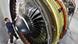 Mann vor Flugzeugtriebwerk Mann vor Flugzeugtriebwerk