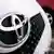 Toyota-Logo am Kühlergrill eines Yaris. Toyota kann mit spritsparenden Modellen punkten, Quelle: AP
