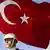 Turkish soldier stands under the Turkish flag