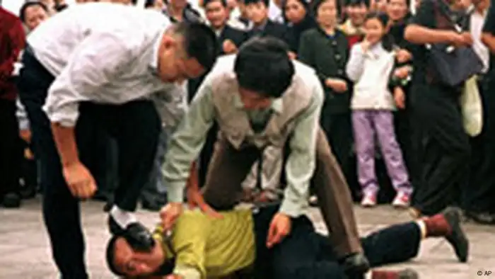 ** File ** Police detain a Falun Gong protester in Tiananmen Square as a crowd watches in Beijing in this Oct. 1, 2000 file photo. China has failed to live up to promises to improve human rights for the 2008 Olympics in Beijing despite death penalty reforms and increased freedoms for foreign reporters, Amnesty International said in a report released Monday April 30, 2007. (AP Photo/Chien-min Chung)