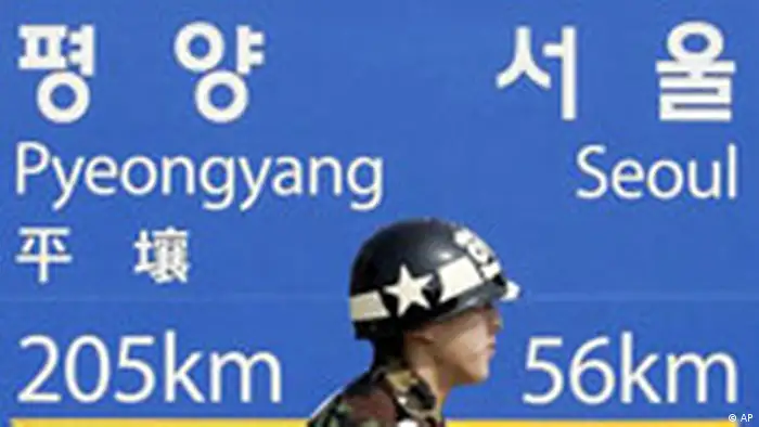 A South Korean military police walks past in front of signboard showing the distance to the North Korean capital Pyongyang and South Korean capital Seoul from Dorasan Station, the last stop in South Korea on a rail link, in the demilitarized zone that separates the two Koreas since the Korean War, in Paju, north of Seoul, South Korea, Thursday, March 15, 2007. Talks between North and South Korea on details of an agreement to conduct test-runs of railways across their heavily armed border ended inconclusively Thursday, the South's Unification Ministry said. (AP Photo/Lee Jin-man)