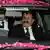 Iftikhar Chaudry auf dem Beifahrersitz eines schwarzen Autos, auf dem rosafarbene Rosenblätter liegen.(Quelle: AP)