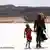 Ein Mann und ein Mädchen gehen durch die Wüste. Quelle: Kinowelt Filmverleih