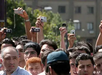 Iranians take pictures and video with cell phones and cameras as authorities hang two men convicted of killing a prominent judge, a police officer and a bystander in a string of robberies and attacks, in Tehran, Iran, Thursday, Aug. 2, 2007. Flanked by masked hangmen, Majid Kavoosifar, 28, and his cousin Hossein Kavoosifar, 24, were executed in front of the main offices of the judiciary in central Tehran. The two men were convicted of shooting dead Judge Hassan Moqaddas in his car outside his central Tehran office in August 2005. (AP Photo/Vahid Salemi)