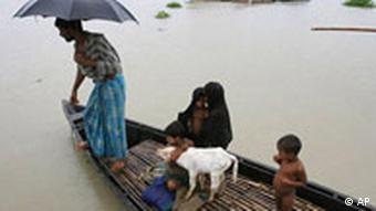 Eine Familie verlässt in einem Boot ihr überschwemmtes Haus, Quelle: AP