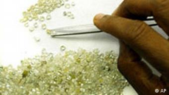 A hand is shown sorting small diamonds