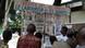 A group of men look at pinned up newspapers A group of men look at pinned up newspapers