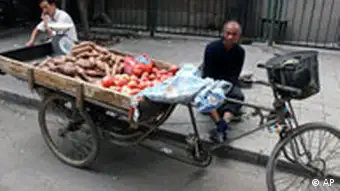 A street vendor waits for customer, showing tomatoes and potatoes on his tricycle's back, on a backstreet in Beijing, Monday, Sept. 24, 2007. China said Monday it had boosted inspections of agriculture products nationwide in a bid to cut the use of banned pesticides and the overuse of animal feed additives and fertilizers. (AP Photo/Shuji Kajiyama)