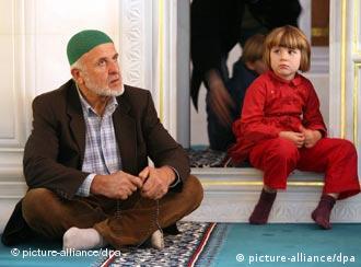 A man and small child sit in a mosque
