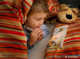 A child reads a book in bed