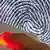A finger gets scanned with a large image of a fingerprint in the background