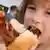 Djevojčica jede vruću kobasicu