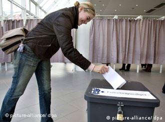 Eine Frau wirft ihren Wahlzettel in die Urne bei der dänischen Nationalwahl in Dänemark am 13.11.2007 (Quelle: dpa)