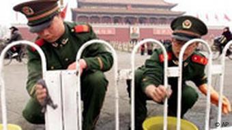 Chinesische Polizisten putzen einen Zaun vor dem Tor des himmlischen Friedens