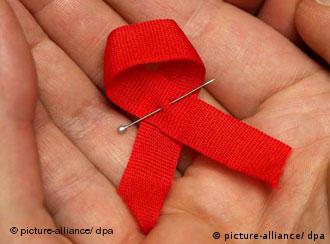 An AIDS ribbon in a person's hand
