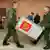 Two soldiers carry a Russian ballot box