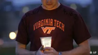 Sophomore Kenneth Erisman holds a candle as he pays his respects at a makeshift memorial at Drill field on the Virginia Tech campus Wednesday, April 18, 2007 in Blacksburg, Va. Midway through his murderous rampage, Virginia Tech gunman Cho Seung-Hui went to the post office and mailed NBC a package containing photos and videos of him brandishing guns and delivering a snarling, profanity-laced tirade about rich brats and their hedonistic needs. (AP Photo/Mary Altaffer)