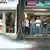 Ein Gruppe junger Männer steht vor einem Handy-Geschäft (Aida Cama)