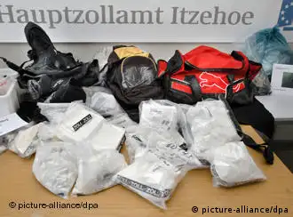 43 Pakete mit insgesamt 22,7 kg Kokain, zwei salzverkrustete Rucksäcke und eine Tasche liegen am Donnerstag (23.08.2007) im Zollfahndungsamt Kiel auf einem Tisch. Die Zöllner haben die Herkunft der im März am Strand von Sylt entdeckten Kokainpakete geklärt. Sie stammen von Bord eines südamerikanischen Containerschiffes. Bereits Ende Februar wurden in Antwerpen fünf Männer festgenommen, als sie rund 200 Kilogramm Kokain von Bord des Schiffes schmuggeln wollten. Als dieses seine Fahrt von Antwerpen nach Bremerhaven fortsetzte, warf ein weiterer Komplize vermutlich aus Angst vor einer neuen Durchsuchung in Bremerhaven das Rauschgift ins Meer. Foto: Christian Hager dpa/lno +++(c) dpa - Report+++