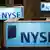 Lighted NYSE signs sit atop trading post on the floor of the New York Stock Exchange