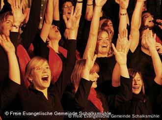 Sänger des Living Gospel-Chor werfen die Arme in die Höhe (Foto: Freie Evangelischen Gemeinde Schalksmühle)
