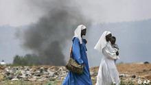 Nuns carry a small child down the road during skirmishes between police and opposition supporters in Kisumu, Kenya, Friday, Feb. 1, 2008. Police fired tear gas and live rounds Friday at scores of protesters trying to block the main road following the death of a 12-year-old boy from a gunshot wound to the head. (AP Photo/Ben Curtis)