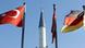 German and Turkish flags flank a minaret German and Turkish flags flank a minaret