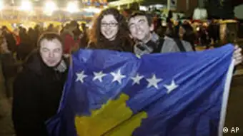 Kosovars hold the new national flag as they celebrate Kosovo's declaration of independence in the capital, Pristina, Sunday, Feb. 17, 2008