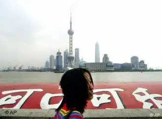 A tourist walks past a Chinese sign of Coca Cola as skyscrapers tower into clouds as back ground Monday, Oct. 29, 2001 in Shanghai. They've had years to prepare, but China's companies, farmers and workers face wrenching changes once they enter the free-market World Trade Organization (WTO), letting loose a flood of imports and foreign competition. (AP Photo/Eugene Hoshiko)