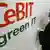 Employee at CeBit prepares for the fair by hanging up sign which states "Green it."