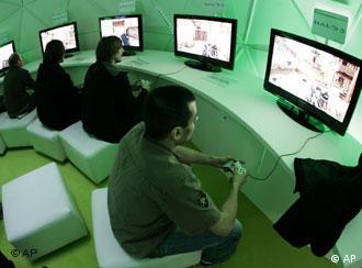 Mehrere junge Männer sitzen in einem Raum mit grünlichem Licht auf der Computermesse CeBIT und spielen Computerspiele.
