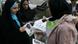 A woman distributes information material for pro--reform candidates in Iran A woman distributes information material for pro--reform candidates in Iran