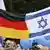 People hold Israeli and German flags