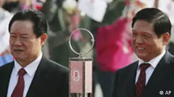 Liu Qi, the president of the Beijing Olympics organizing committee (BOCOG), right, and Politburo Standing Committee member Zhou Yongkang stand behind the Olympic flame on its arrival in China, at Beijing airport Monday March 31, 2008. (AP Photo/Greg Baker)