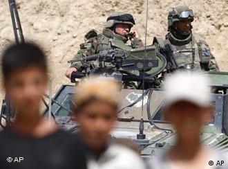 Soladten auf einem Panzer, im Vordergrund (unscharf) mehrere Jungen (29.3.08, Kabul - Afghanistan, Quelle: AP)