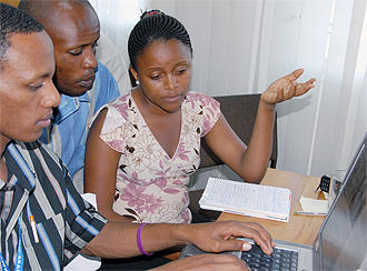 Three participants sit at a computer