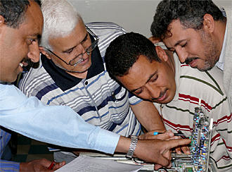 Teilnehmer schauen sich ein technisches Gerät an