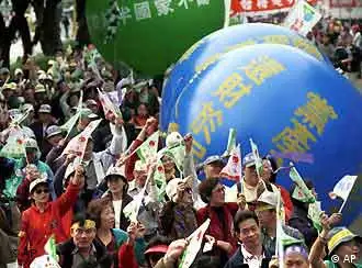 Waving flags and kicking large inflated blue balls with give your assets back to the governement written on them, hundreds of protesters march through Taipei' streets, Sunday, Nov.18, 2001. The protesters were asking for the former ruling Nationalist Party to hand over wealth they claim was illegally stolen from the public during Taiwan's martial law era. The issue is one of the biggest controversy ahead of the Dec.1 mayoral and legislative elections and could prove to be the point of major struggles if the Nationalists lose their majority control in the legislature.