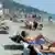 People sunbathing on the beach in Alassio, Italy