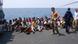 Would-be immigrants stand on the deck of a patrol ship, off the coast of Lampedusa island, near Sicily, southern Italy Would-be immigrants stand on the deck of a patrol ship, off the coast of Lampedusa island, near Sicily, southern Italy