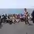 Would-be immigrants stand on the deck of a patrol ship, off the coast of Lampedusa island, near Sicily, southern Italy