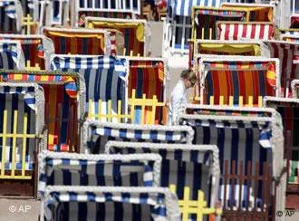 Eine Frau spaziert zwischen Strandkörben am Strand von Timmendorfer Strand (Foto: AP)