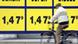 A bike rider passes a sign displaying gasoline prices A bike rider passes a sign displaying gasoline prices