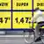 A bike rider passes a sign displaying gasoline prices